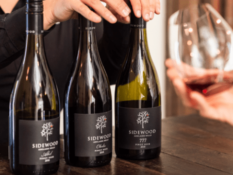 a close up of a person holding a bottle of wine