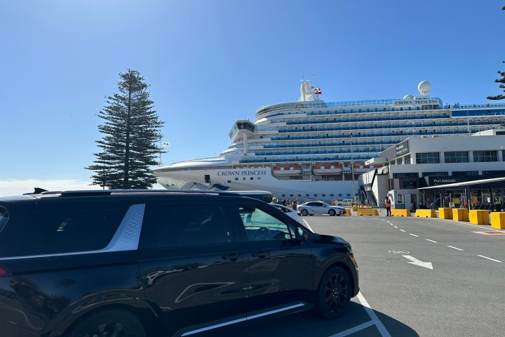 Black SUV parked near cruise ship 'Crown Princess' at dock under clear blue sky.